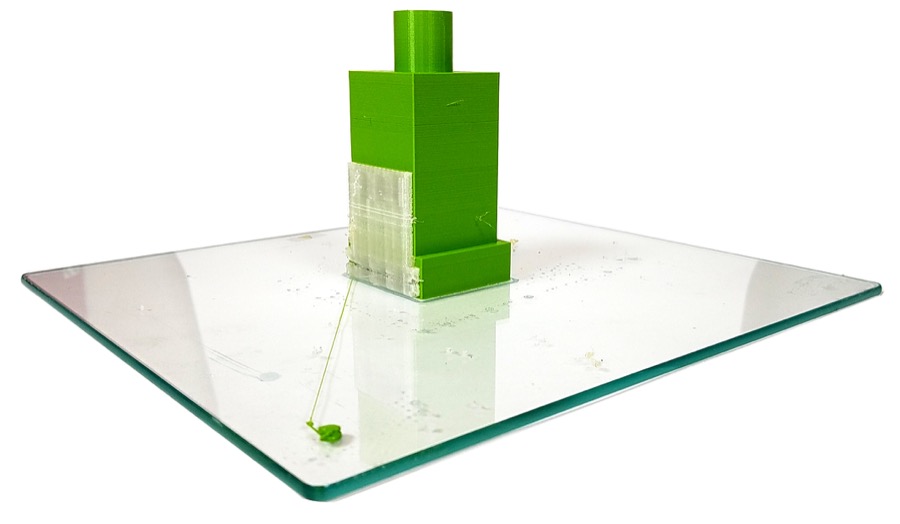 Image of a 3d printed part on glass with support mateiral still attached